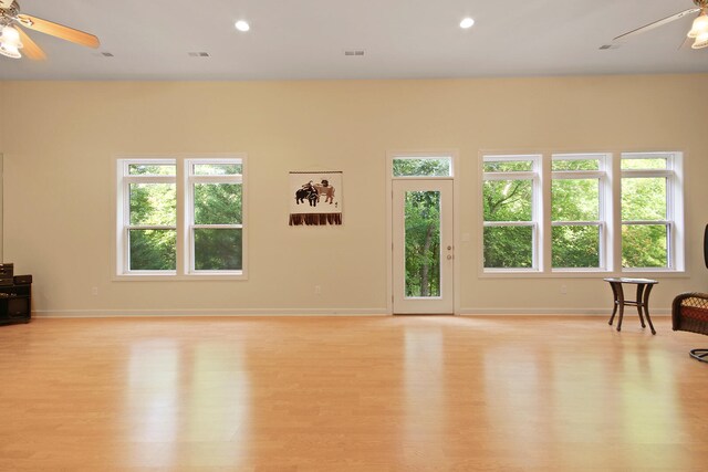 living room featuring light wood-type flooring, ceiling fan, and plenty of natural light