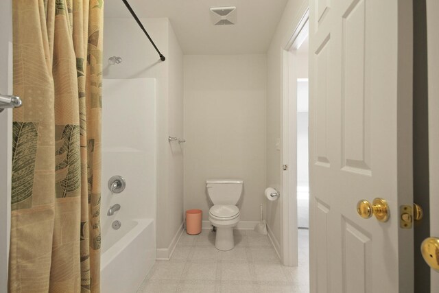 bathroom featuring toilet and shower / bath combination with curtain