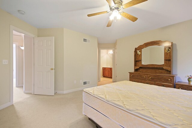 bedroom featuring connected bathroom, light colored carpet, and ceiling fan