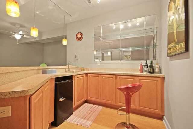 kitchen featuring track lighting, ceiling fan, sink, and light hardwood / wood-style floors