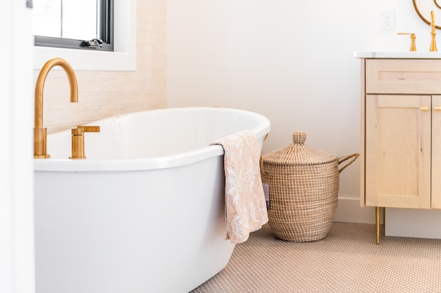 bathroom with vanity, a tub, and tile patterned floors