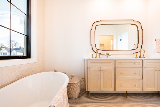 bathroom featuring vanity, a washtub, and tile patterned floors