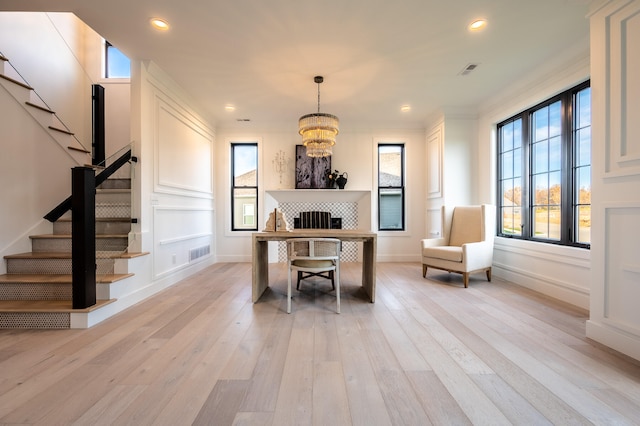 interior space featuring light hardwood / wood-style flooring, a chandelier, and ornamental molding