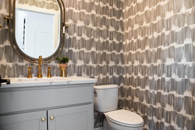 bathroom with vanity, tile walls, and toilet