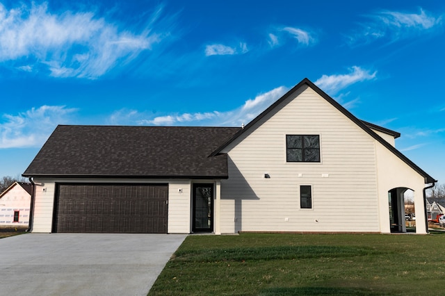 view of front of property featuring a front lawn and a garage