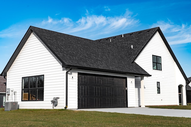 view of front facade with a garage, a front lawn, and central AC