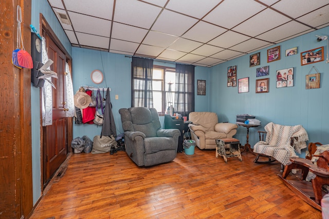 living area featuring hardwood / wood-style flooring and a drop ceiling