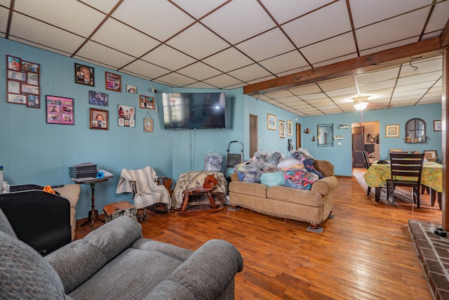 living room featuring a paneled ceiling and hardwood / wood-style floors