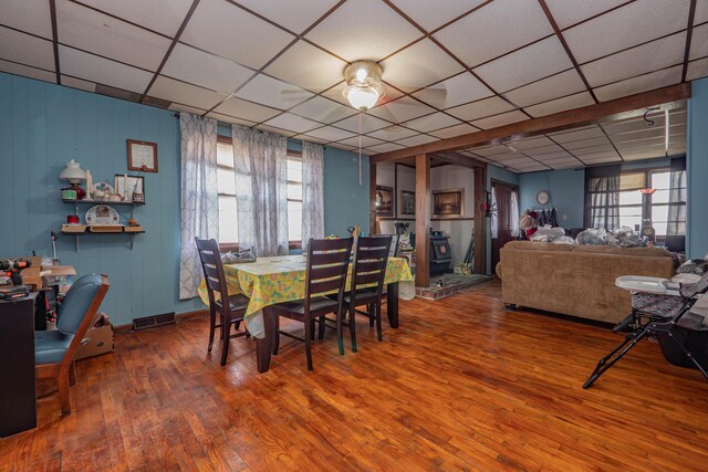 dining area featuring a drop ceiling and wood-type flooring