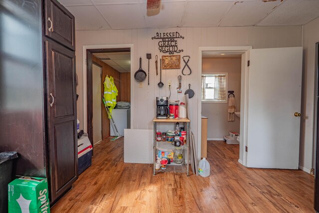 interior space featuring washer / dryer, light hardwood / wood-style floors, and wooden walls