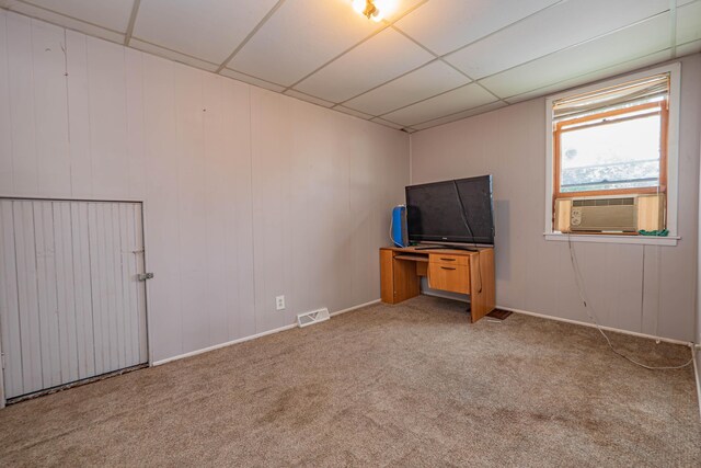 empty room with a drop ceiling, cooling unit, and carpet floors