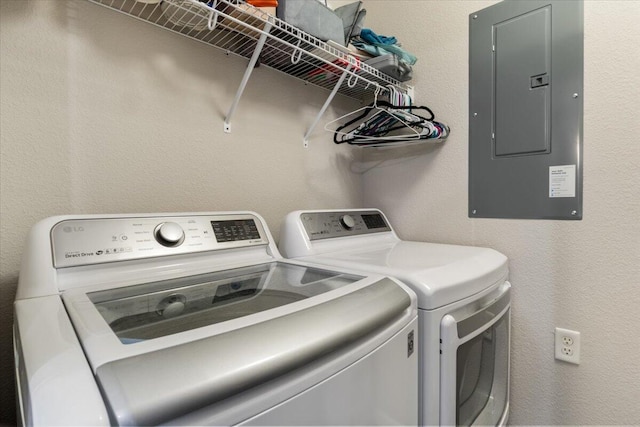 clothes washing area featuring electric panel and washer and clothes dryer