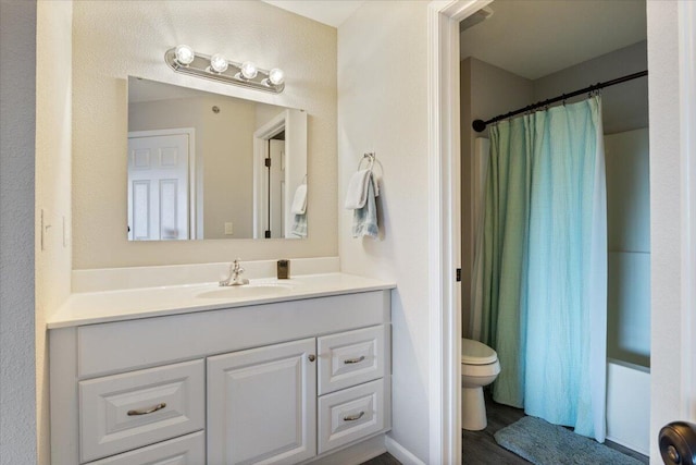 full bathroom with wood-type flooring, shower / bath combo, vanity, and toilet