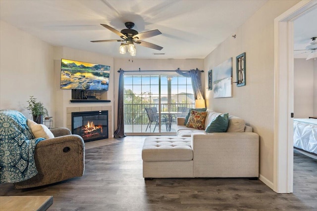 living room with ceiling fan, a fireplace, and dark hardwood / wood-style flooring