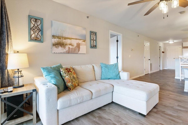 living room featuring ceiling fan and hardwood / wood-style flooring