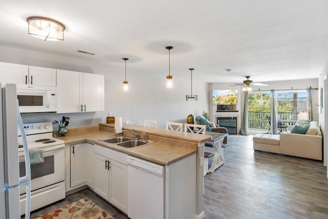 kitchen with white appliances, dark wood-type flooring, white cabinets, and kitchen peninsula