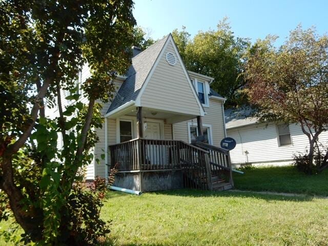 back of house with a wooden deck and a lawn