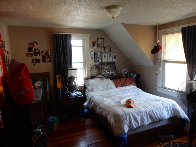 bedroom featuring a textured ceiling, lofted ceiling, and dark hardwood / wood-style flooring