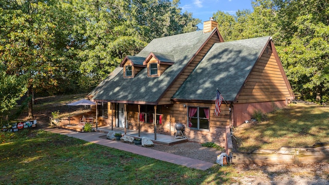 rear view of property featuring a yard and a patio