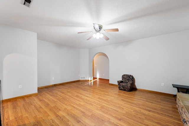 interior space featuring light wood-type flooring, a textured ceiling, and ceiling fan