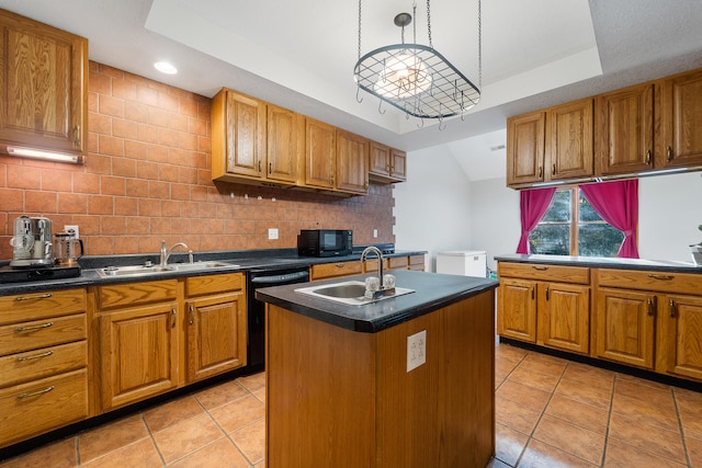 kitchen with pendant lighting, an island with sink, sink, tasteful backsplash, and black appliances