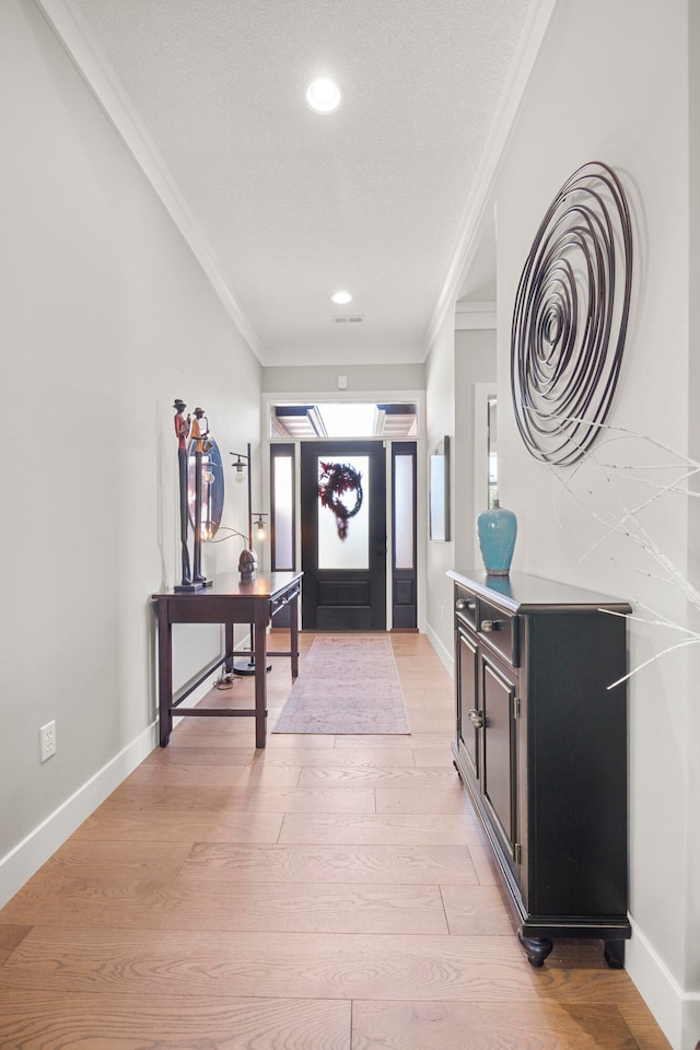 entrance foyer with ornamental molding and light wood-type flooring