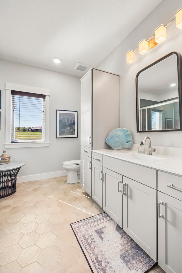 bathroom featuring tile patterned floors, a shower with door, vanity, and toilet