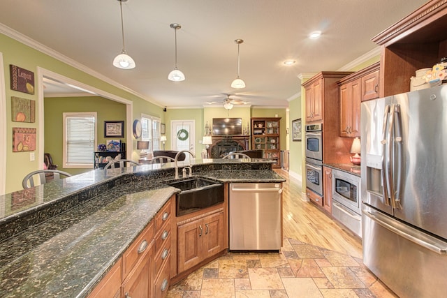 4200 S Rangeline Rd, Columbia, MO 65201 - kitchen featuring appliances with stainless steel finishes, a sink, a ceiling fan, crown molding, and brown cabinets