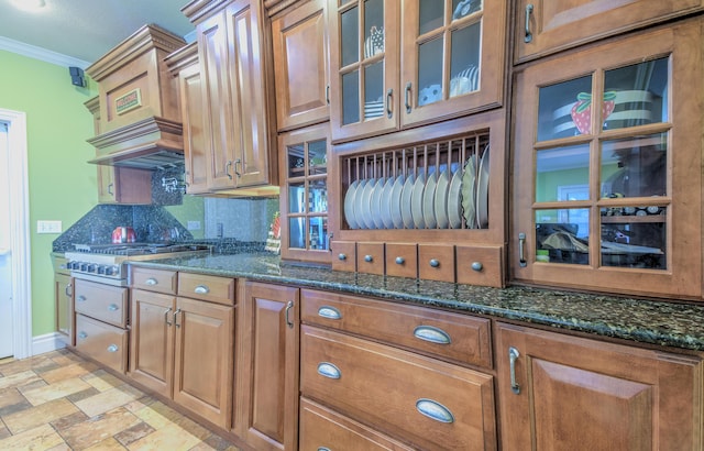 4200 S Rangeline Rd, Columbia, MO 65201 - kitchen with backsplash, ornamental molding, dark stone countertops, glass insert cabinets, and light stone finish flooring