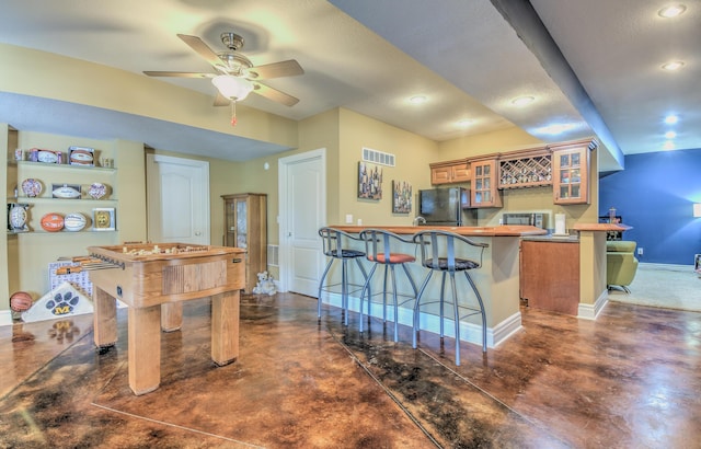 4200 S Rangeline Rd, Columbia, MO 65201 - kitchen with freestanding refrigerator, a peninsula, a kitchen bar, baseboards, and glass insert cabinets
