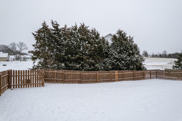 yard covered in snow featuring a fenced backyard