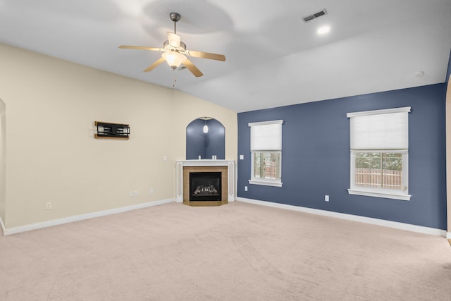 unfurnished living room featuring baseboards, visible vents, a fireplace with flush hearth, and light colored carpet