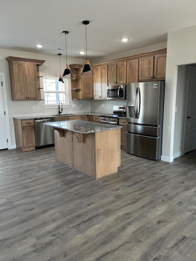 kitchen featuring dark hardwood / wood-style flooring, a center island, decorative light fixtures, and appliances with stainless steel finishes