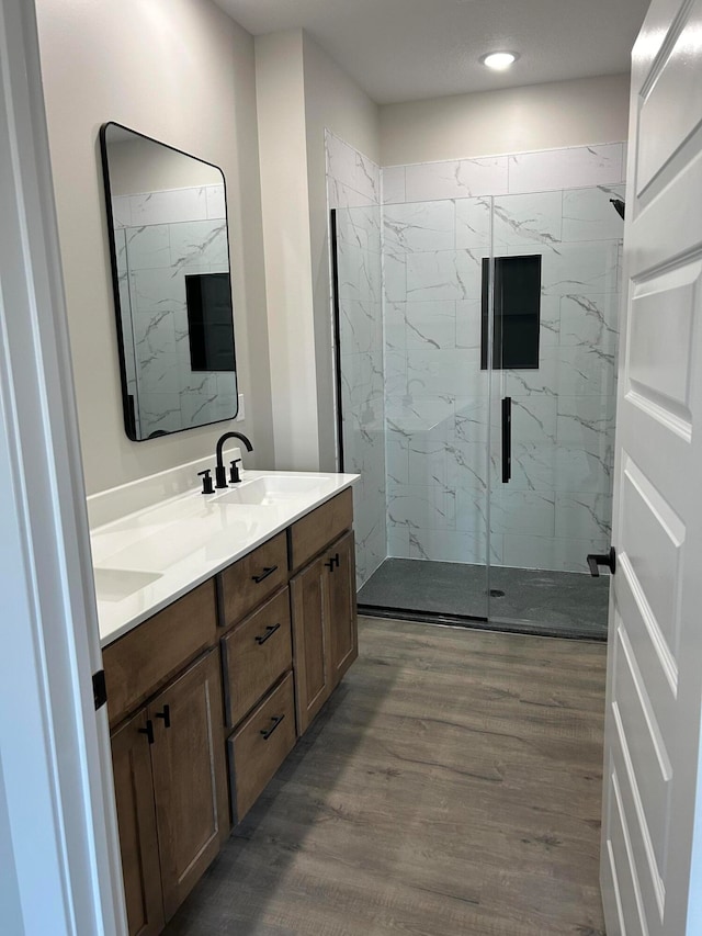 bathroom with vanity, wood-type flooring, and an enclosed shower