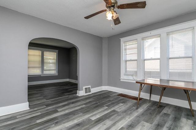 unfurnished room with ceiling fan and dark wood-type flooring