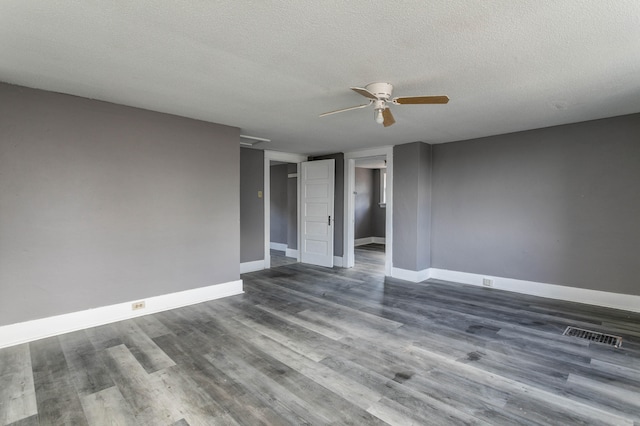 spare room with a textured ceiling, ceiling fan, and dark hardwood / wood-style flooring