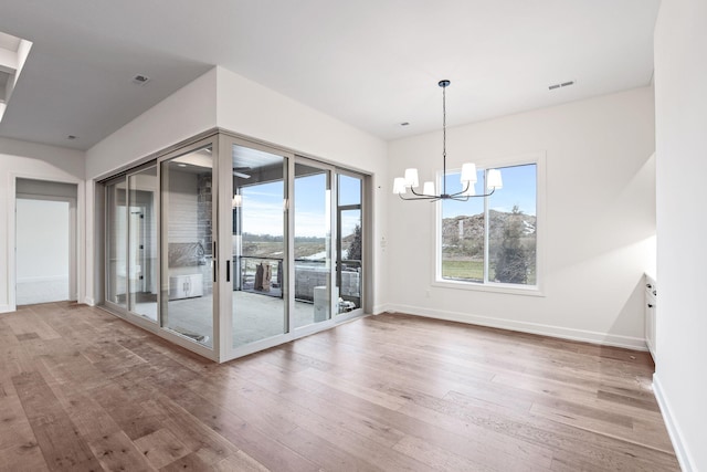 unfurnished room featuring wood-type flooring and a chandelier