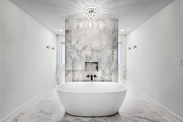 bathroom featuring a textured ceiling, tile walls, plenty of natural light, and a washtub