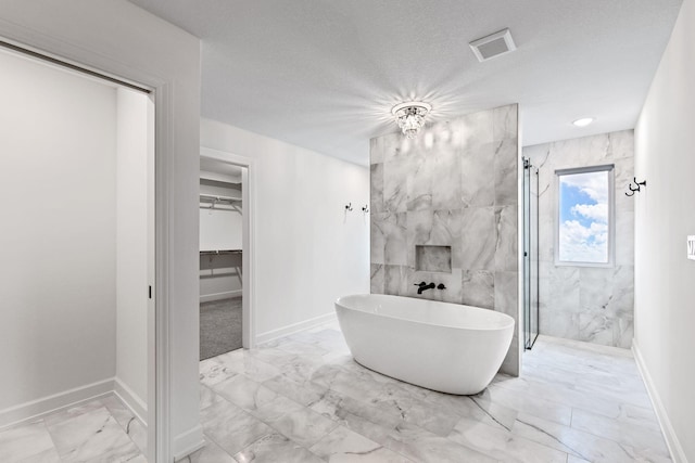 bathroom with shower with separate bathtub, tile walls, and a textured ceiling