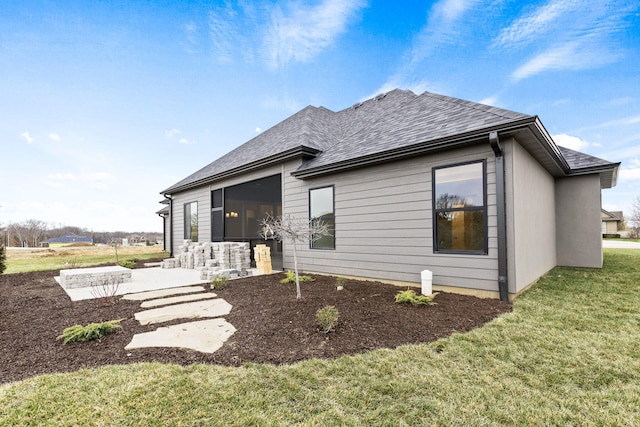 back of property with a yard and a patio area