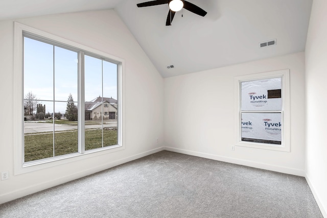 spare room with carpet flooring, vaulted ceiling, ceiling fan, and a wealth of natural light