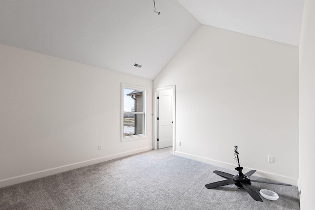 carpeted spare room featuring vaulted ceiling