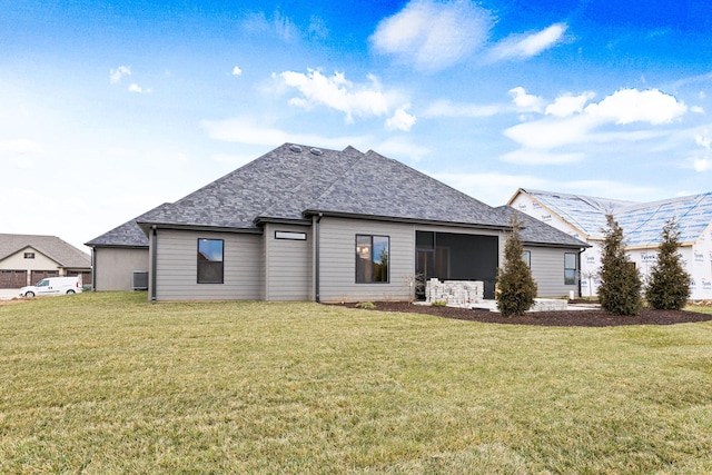 rear view of house featuring a lawn and a sunroom