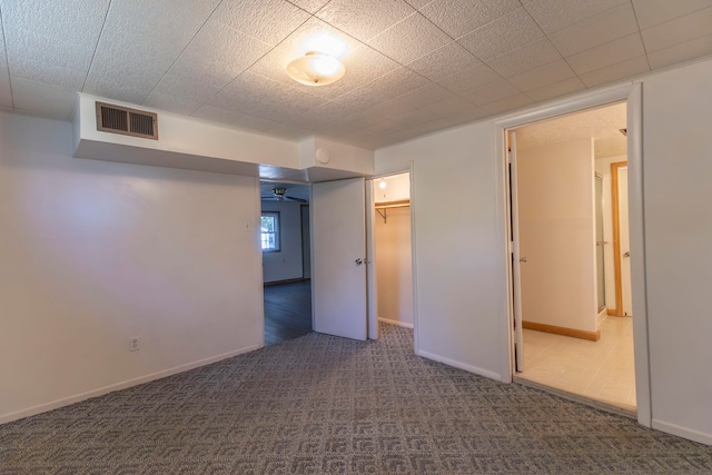 spare room featuring dark colored carpet