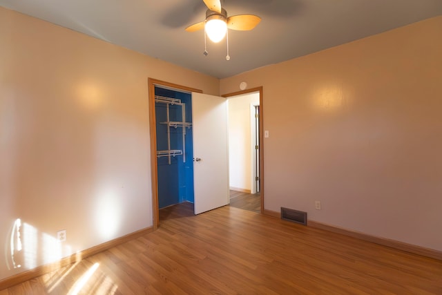 unfurnished bedroom with ceiling fan, a closet, and hardwood / wood-style floors