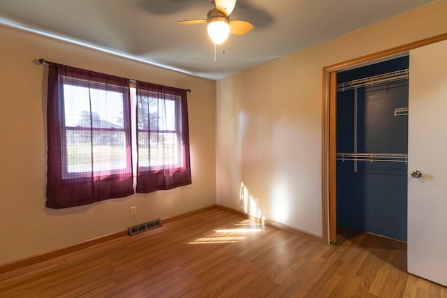 unfurnished bedroom with hardwood / wood-style floors, ceiling fan, and a closet