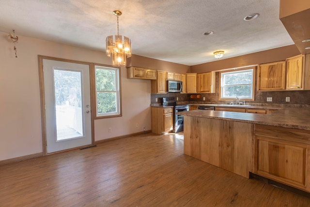 kitchen featuring sink, decorative light fixtures, stainless steel appliances, light wood-type flooring, and decorative backsplash