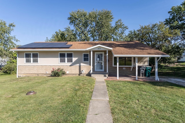 view of front of house featuring a patio, a front lawn, and solar panels