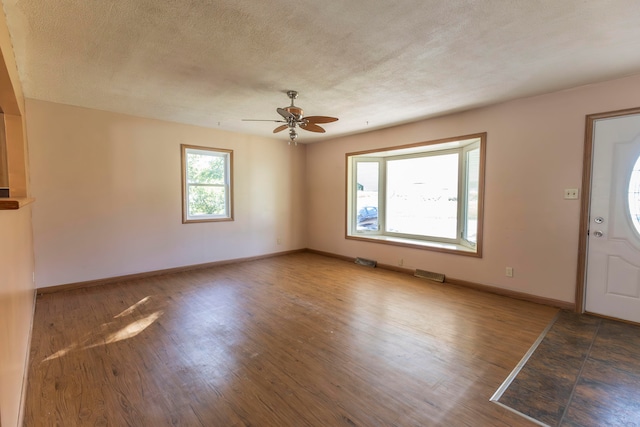 foyer featuring a textured ceiling, wood-type flooring, and ceiling fan