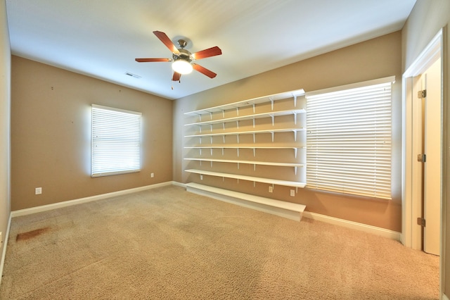 carpeted spare room featuring ceiling fan